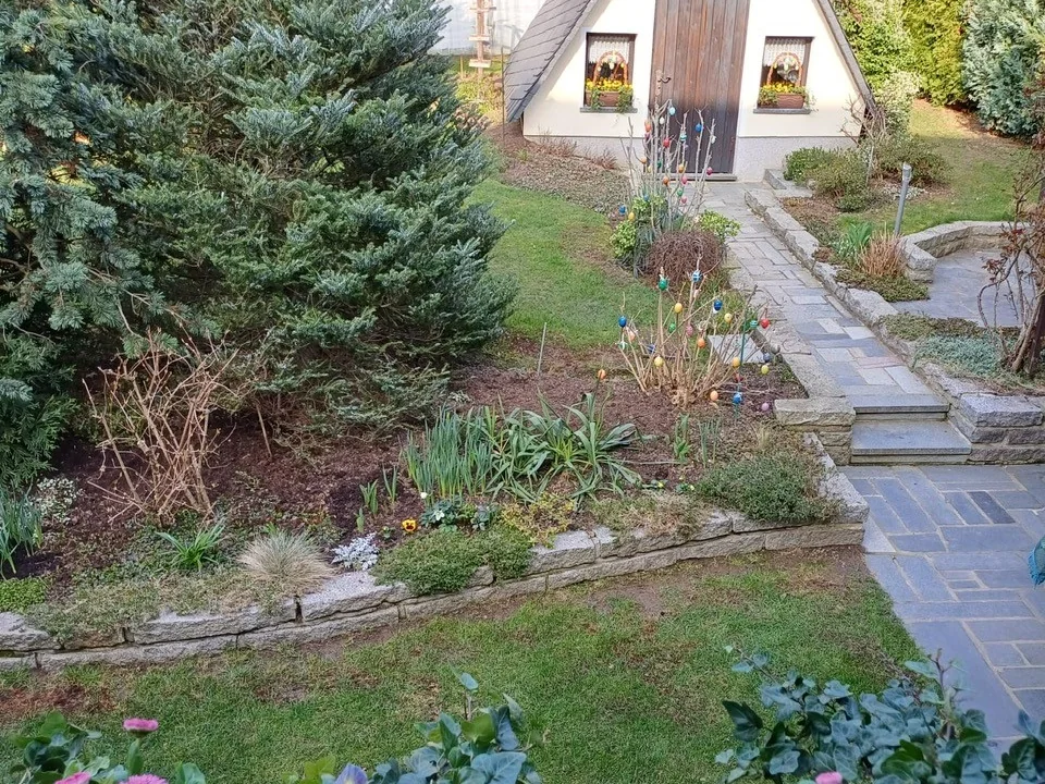 Kleines Gartenhaus und angelegte Wege im Garten